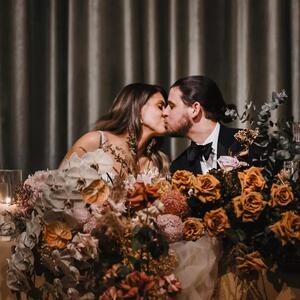 Nothing sets the mood for that newly wed kiss quite like a bridal table like this 💌  A fusion of our favourite premium roses, in shades of caramel and mauve, paired with sweeping orchids and ornamental greenery helped create the scene for this beautiful moment between Antonia & Luke. A magical night that we'll forever be grateful to be part of x
Bride: @antonia.dimas09 
Photography: @inlightenphotography
Florals & Styling: @thegroundsfloralsbysilva
Venue: @thegrounds // @thegroundsevents

#TheGroundsFloralsBySilva